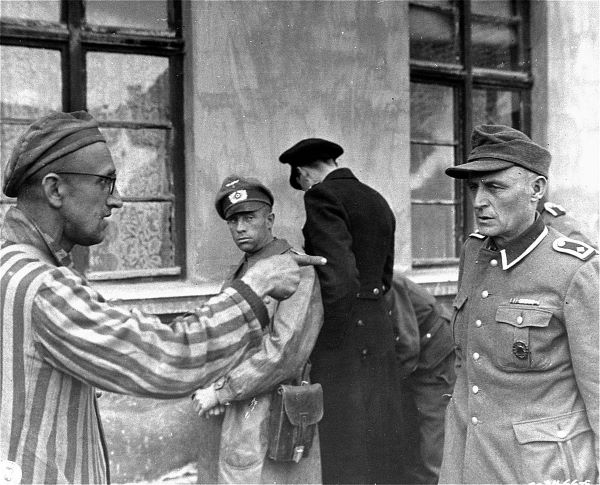 Więzień Buchenwaldu pokazuje strażnika podczas wyzwolenia obozu. Źródło zdjęcia: Wikipedia, domena publiczna.