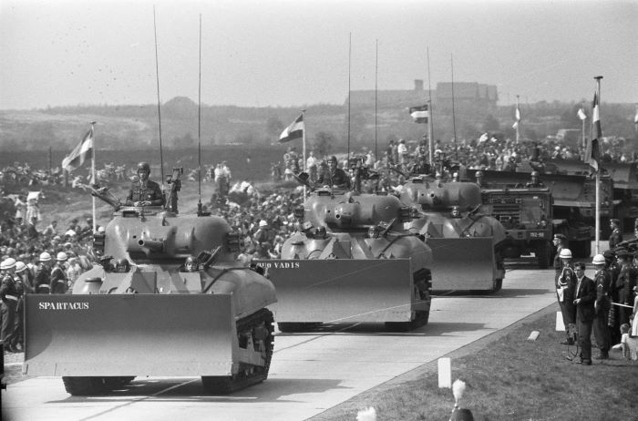 Shermany z lemieszami podczas defilady armii niderlandzkiej w Ede 5 maja 1960 roku. Zdjęcie to wskazuje, że montowanie lemieszy do Shermanów cieszyło się popularnością także po zakończeniu wojny. Źródło: Wikimedia/Nationaal Archief, CC0.