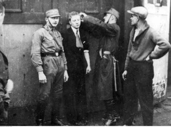 Patrol SA strzyże włosy Żydowi - była to jedna w form represji stosowanych przez Niemców wobec ludności żydowskiej. Źródło zdjęcia: NAC.